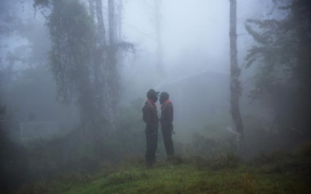 TOPSHOT - Two members of the now demobilized Zapatista Army of National Liberation (EZLN) group, led by insurgent Subcommander Moises (out of frame), take part in the celebration of the 32th anniversary of their first armed uprising - on January 1, 1994 - against the Mexican government, at the autonomous community of Caracol number 3 in Oventic, Chiapas State, Mexico on December 31, 2025. (Photo by Alejandro MELENDEZ / AFP)