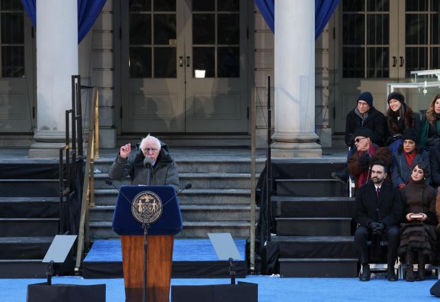 New York mayor Zohran Mamdani and his wife Rama Duwaji listen to US Senator Bernie Sanders speak during New York mayor Zohran Mamdani's public inauguration ceremony followed by a block party at City Hall in New York on January 1, 2026. Mamdani, the young upstart of the US left, was sworn in Thursday to take over as New York mayor for a term sure to see him cross swords with President Donald Trump. After the clocks struck midnight, bringing in 2026, Mamdani took his oath of office at an abandoned subway stop to begin managing the United States' largest city. He is New York's first Muslim mayor. (Photo by ANGELA WEISS / AFP)