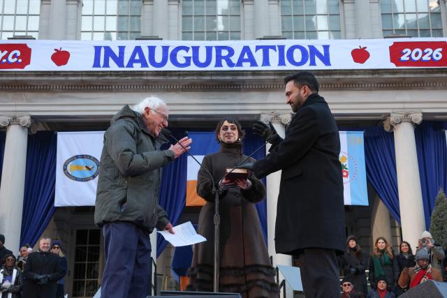 US Senator Bernie Sanders swears in New York mayor Zohran Mamdani as his wife Rama Duwaji holds the Koran during his public inauguration ceremony followed by a block party at City Hall in New York on January 1, 2026. Mamdani, the young upstart of the US left, was sworn in Thursday to take over as New York mayor for a term sure to see him cross swords with President Donald Trump. After the clocks struck midnight, bringing in 2026, Mamdani took his oath of office at an abandoned subway stop to begin managing the United States' largest city. He is New York's first Muslim mayor. (Photo by TIMOTHY A. CLARY / AFP)