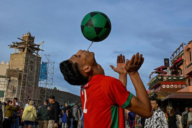 A Moroccan youth performs with a ball in Marrakesh's Jemaa el-Fna Square on January 1, 2026, during the Africa Cup of Nations (CAN) football tournament. (Photo by Khaled DESOUKI / AFP)