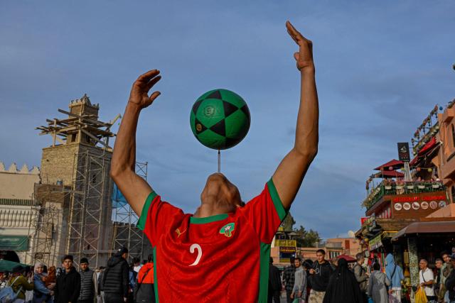 A Moroccan youth performs with a ball in Marrakesh's Jemaa el-Fna Square on January 1, 2026, during the Africa Cup of Nations (CAN) football tournament. (Photo by Khaled DESOUKI / AFP)