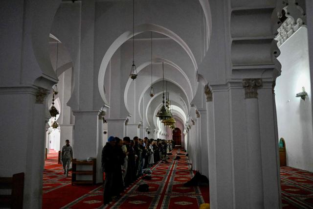 Muslims perform the Asr prayer at the Koutoubia Mosque in Marrakesh on January 1, 2026, during the Africa Cup of Nations (CAN) football tournament. (Photo by Khaled DESOUKI / AFP)