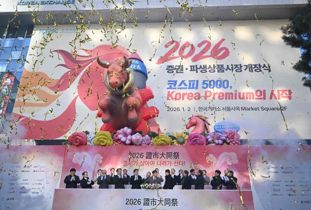 South Korean financial officers celebrate beneath inflatable figures of a bull (L) and a horse (R) during a ceremony celebrating the New Year's opening of the South Korea stock market at the Korea Exchange in Seoul on January 2, 2026. (Photo by Jung Yeon-je / AFP)