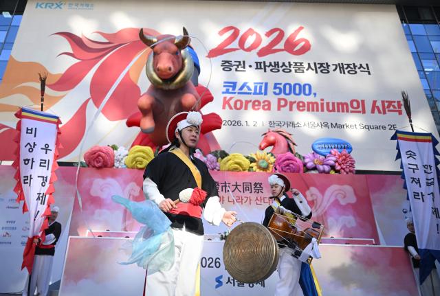 Traditional dancers perform beneath inflatable figures of a bull (L) and a horse (R) during a ceremony celebrating the New Year's opening of the South Korea stock market at the Korea Exchange in Seoul on January 2, 2026. (Photo by Jung Yeon-je / AFP)