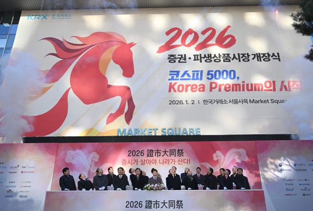 South Korean financial officers celebrate during a ceremony celebrating the New Year's opening of the South Korea stock market at the Korea Exchange in Seoul on January 2, 2026. (Photo by Jung Yeon-je / AFP)