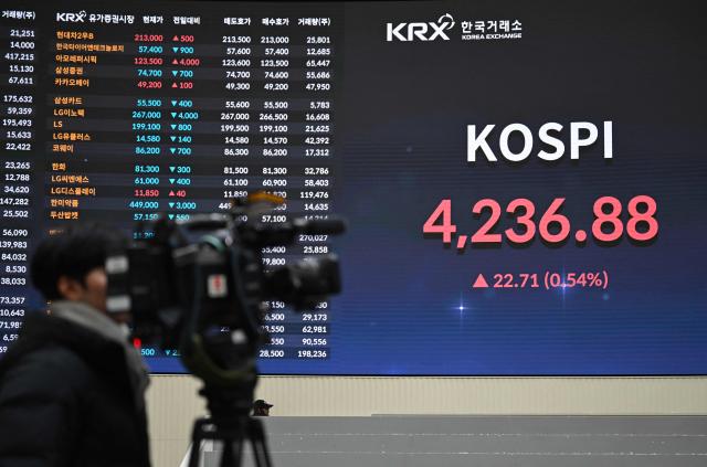 A cameraman films a stock index board showing South Korea's benchmark stock index after a ceremony celebrating the New Year's opening of the South Korea stock market at the Korea Exchange in Seoul on January 2, 2026. (Photo by Jung Yeon-je / AFP)