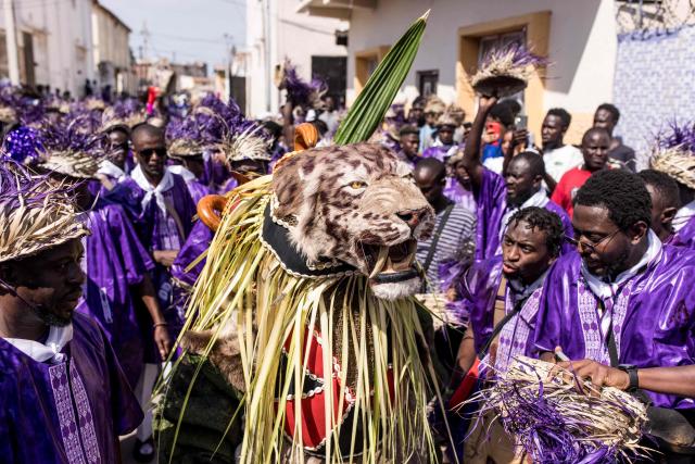 TOPSHOT - Members of the "Odilleh" Hunting Society carry a taxidermied tiger head in the streets ahead of the annual New Years Hunting Festival in Banjul on January 1, 2026. Deeply rooted in tradition, the festival has become a cherished New Year celebration in The Gambia, marked by music, dancing, and vibrant masquerades. Held in the capital city, Banjul, the event features a friendly yet fierce competition among hunting societies Ekun Baba, Odilleh, and the recently joined Gun Shot Hunting Society as they showcase striking animal head displays, masks, and elaborate costumes. (Photo by Muhamadou BITTAYE / AFP)