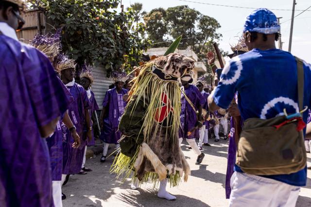 Members of the "Odilleh" Hunting Society carry a taxidermied tiger head in the streets ahead of the annual New Years Hunting Festival in Banjul on January 1, 2026. Deeply rooted in tradition, the festival has become a cherished New Year celebration in The Gambia, marked by music, dancing, and vibrant masquerades. Held in the capital city, Banjul, the event features a friendly yet fierce competition among hunting societies Ekun Baba, Odilleh, and the recently joined Gun Shot Hunting Society as they showcase striking animal head displays, masks, and elaborate costumes. (Photo by Muhamadou BITTAYE / AFP)