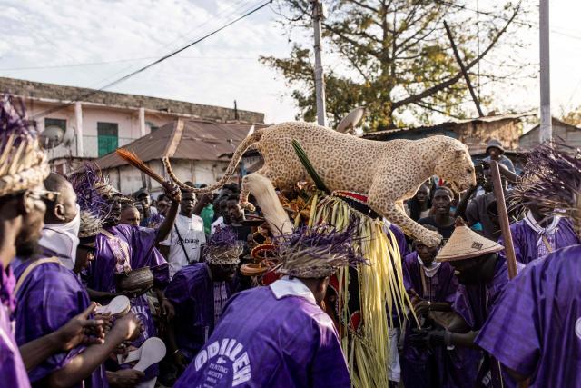 Members of the "Odilleh" Hunting Society carry a taxidermied leopard in the streets ahead of the annual New Years Hunting Festival in Banjul on January 1, 2026. Deeply rooted in tradition, the festival has become a cherished New Year celebration in The Gambia, marked by music, dancing, and vibrant masquerades. Held in the capital city, Banjul, the event features a friendly yet fierce competition among hunting societies Ekun Baba, Odilleh, and the recently joined Gun Shot Hunting Society as they showcase striking animal head displays, masks, and elaborate costumes. (Photo by Muhamadou BITTAYE / AFP)