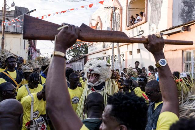 TOPSHOT - Members of the Ekun-Baba Odeh hunting society showcase their animal head during the annual New Years Hunting Festival in Banjul on January 1, 2026. Deeply rooted in tradition, the festival has become a cherished New Year celebration in The Gambia, marked by music, dancing, and vibrant masquerades. Held in the capital city, Banjul, the event features a friendly yet fierce competition among hunting societies Ekun Baba, Odilleh, and the recently joined Gun Shot Hunting Society as they showcase striking animal head displays, masks, and elaborate costumes. (Photo by Muhamadou BITTAYE / AFP)