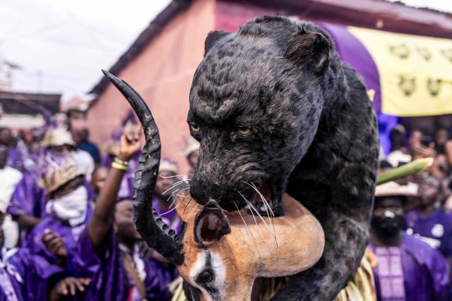 Members of the "Odilleh" Hunting Society carry a items that resemble a panther and an antelope in the streets ahead of the annual New Years Hunting Festival in Banjul on January 1, 2026. Deeply rooted in tradition, the festival has become a cherished New Year celebration in The Gambia, marked by music, dancing, and vibrant masquerades. Held in the capital city, Banjul, the event features a friendly yet fierce competition among hunting societies Ekun Baba, Odilleh, and the recently joined Gun Shot Hunting Society as they showcase striking animal head displays, masks, and elaborate costumes. (Photo by Muhamadou BITTAYE / AFP)