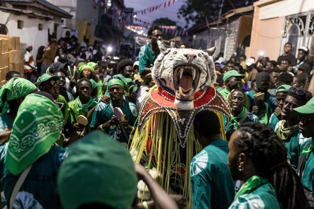 Members of Fojuseleh another hunting society showcase their animal head during the annual New Years Hunting Festival in Banjul on January 1, 2026. Deeply rooted in tradition, the festival has become a cherished New Year celebration in The Gambia, marked by music, dancing, and vibrant masquerades. Held in the capital city, Banjul, the event features a friendly yet fierce competition among hunting societies Ekun Baba, Odilleh, and the recently joined Gun Shot Hunting Society as they showcase striking animal head displays, masks, and elaborate costumes. (Photo by Muhamadou BITTAYE / AFP)