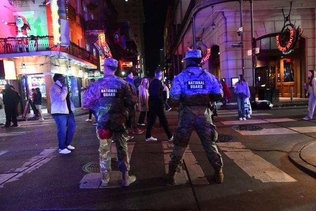 Members of the Louisiana National Guard stand watch on Bourbon Street in the French Quarter as authorities anticipate large crowds due to a college football game quarterfinal in New Orleans, Louisiana, on January 1, 2026. (Photo by Octavio JONES / AFP)