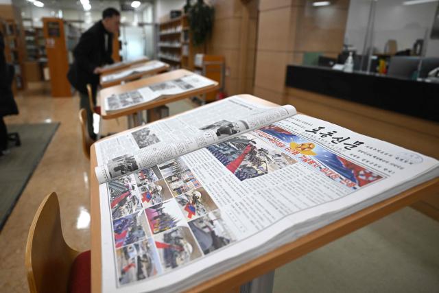 TOPSHOT - A collection of issues of Rodong Sinmun, North Korea's top newspaper, is displayed at the National Library of Korea in Seoul on January 2, 2026. Packed with missile tests, thunderous tirades against the United States and tributes to the glories of the great leaders -- for decades, Seoul considered North Korea's top newspaper so dangerous its citizens were banned from reading it. But dovish President Lee Jae Myung is now seeking to ease tensions with Pyongyang and has joked that he doesn't believe the public will "become commies" just from reading it. That means from this week South Koreans can access the Rodong Sinmun -- meaning "Workers newspaper" -- at select locations without state approval. (Photo by Jung Yeon-je / AFP)