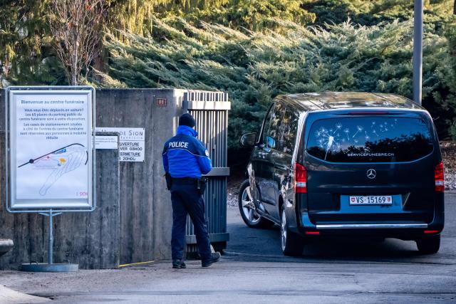 A hearse arrives at the funeral home in Sion on January 2, 2026 the day after a fire that ripped through a bar in the Alpine ski resort of Crans-Montana on January 1, 2026, killing around 40 people and injuring about 115 others. Investigators raced on January 2, 2026 to identify the victims of a fire that ripped through a bar in the Swiss Alps town of Crans-Montana, turning a New Year's celebration into one of the country's worst tragedies. Frederic Gisler, police commander in the Wallis canton in southwestern Switzerland, told reporters that authorities had counted "around 40 people who have died and around 115 injured, most of them seriously". (Photo by MAXIME SCHMID / AFP)