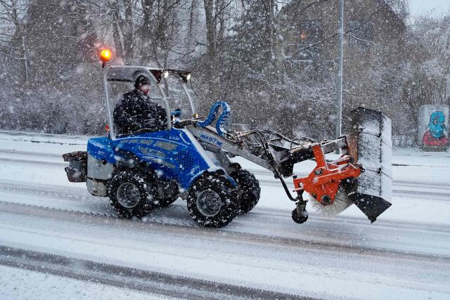 A man on a snowplough drives on a snow-covered street in Aalborg, Denmark, on January 2, 2026, as the country experiences a weather change due to a large low-pressure system. (Photo by Henning Bagger / Ritzau Scanpix / AFP) / Denmark OUT