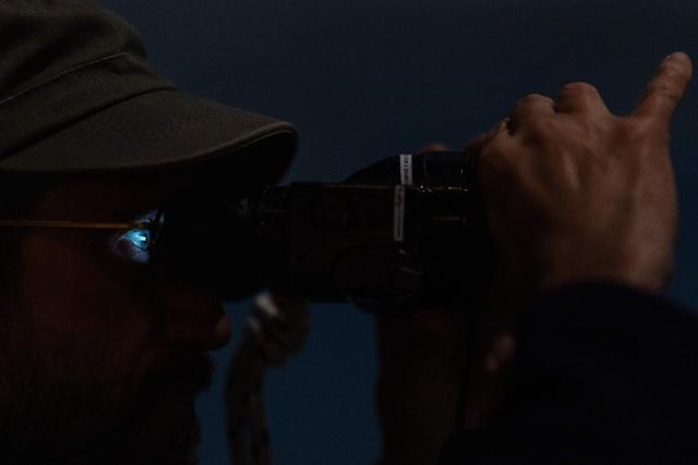 A crew member of the rescue ship “Ocean Viking” operated by the NGO SOS Mediterranee, uses night vision binoculars during a night watch as part of a patrol in the search-and-rescue zone of the international waters of Malta, on January 1, 2026. 33 migrants were rescued by crew members of the migrants rescue ship "Ocean Viking" operated by the NGO SOS Mediterranee. They had been stranded on the oil tanker the 'Maridive 703' since their initial rescue 5 days ago in the joint search zone between Malta and Tunisia in international Mediterranean waters. (Photo by Sameer Al-DOUMY / AFP)