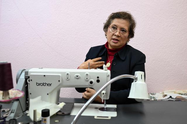 Mexican seamstress and designer Olivia Trujillo Cortes, 63, speaks during an interview in her workshop in San Pedro Martir, on the outskirts of Mexico City, on December 23, 2025. Mexican President Claudia Sheinbaum wore a purple, indigenous-embroidered dress at her first meeting with Donald Trump during the 2026 World Cup draw, a choice seen as symbolizing women's power. That week, The New York Times named her among the world's most stylish figures, highlighting her strategy of blending indigenous craftsmanship with modern elegance to send a political message. (Photo by Yuri CORTEZ / AFP)