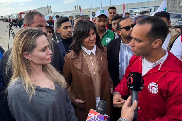 US actress Angelina Jolie speaks to a member of the Egyptian Red Crescent at the Egyptian Rafah border crossing, part of her visit to the North Sinai Governorate to inspect aid entering the Palestinian Gaza Strip, on January 2, 2026, following a two year war that was sparked by Hamas's October 7, 2023 attack on Israel, and which has left the majority of Gaza's 2.4 million people displaced and in need of aid. (Photo by AFP)