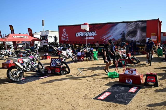 Some of the competitors of the Dakar Rally 2026 prepare their motorbikes at a temporary camp in Yanbu, Saudi Arabia, on January 2, 2026. The 48th edition of the Dakar Rally is set to start the prologue in Yanbu on January 3, 2026. (Photo by Giuseppe CACACE / AFP)