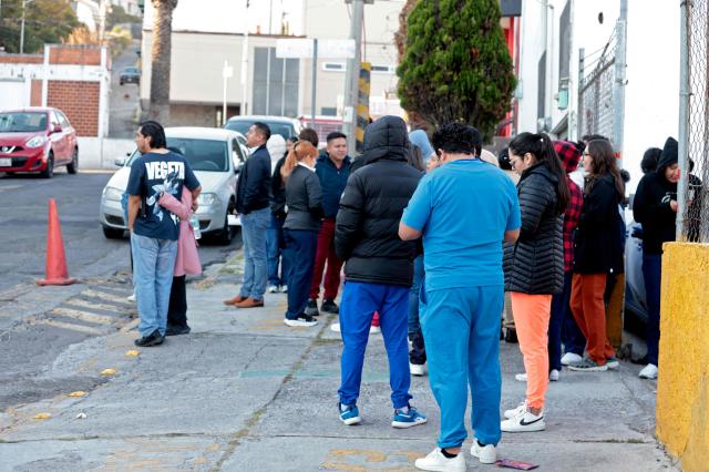 People remain outside after evacuating a hospital building during a 6.5 magnitude earthquake in Puebla, Mexico, on January 2, 2026. A 6.5-magnitude earthquake shook Mexico City and parts of southwestern Guerrero state on Friday, the national seismological service confirmed. (Photo by ULISES RUIZ / AFP)