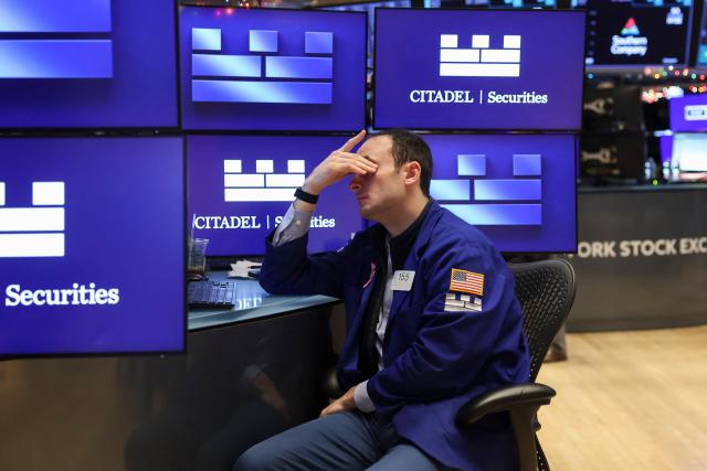 A trader works on the floor of the New York Stock Exchange (NYSE) after the opening bell in New York on January 2, 2026. (Photo by ANGELA WEISS / AFP)