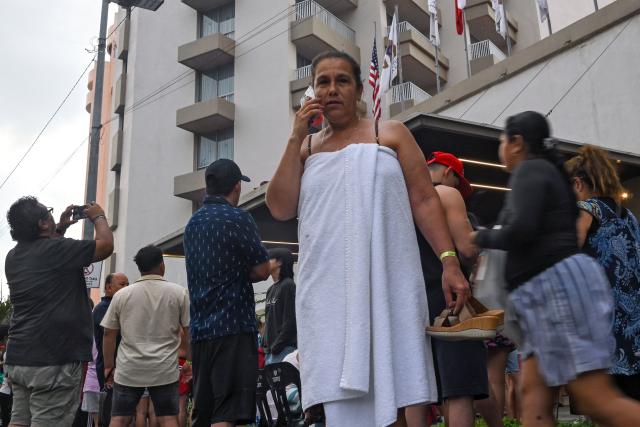 A tourist speaks on ther mobile phone after being evacuated from a hotel during a 6.5 magnitude earthquake in Acapulco, Guerrero state, Mexico on January 2, 2026. A 6.5-magnitude earthquake shook Mexico City and parts of southwestern Guerrero state on Friday, the national seismological service confirmed. (Photo by Francisco ROBLES / AFP)