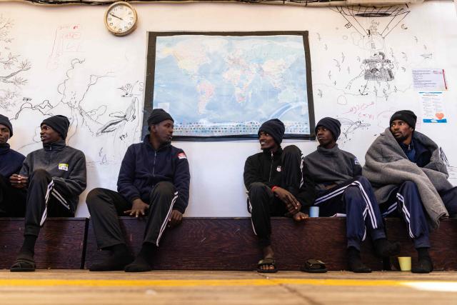 Migrants look on as they sit onboard the rescue ship "Ocean Viking" operated by humanitarian NGO SOS Mediterranee, in the Mediterranean Sea near the Italian coast on January 2, 2026. 33 migrants were rescued by crew members of the migrants rescue ship "Ocean Viking" operated by the NGO SOS Mediterranee. They had been stranded on the oil tanker the 'Maridive 703' since their initial rescue 5 days ago in the joint search zone between Malta and Tunisia in international Mediterranean waters. (Photo by Sameer Al-DOUMY / AFP)