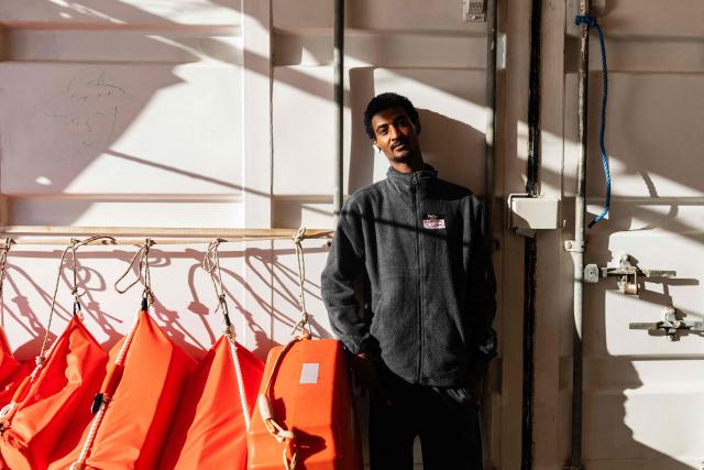 A migrant poses for a photograph onboard the rescue ship "Ocean Viking" operated by humanitarian NGO SOS Mediterranee, in the Mediterranean Sea near the Italian coast on January 2, 2026. 33 migrants were rescued by crew members of the migrants rescue ship "Ocean Viking" operated by the NGO SOS Mediterranee. They had been stranded on the oil tanker the 'Maridive 703' since their initial rescue 5 days ago in the joint search zone between Malta and Tunisia in international Mediterranean waters. (Photo by Sameer Al-DOUMY / AFP)