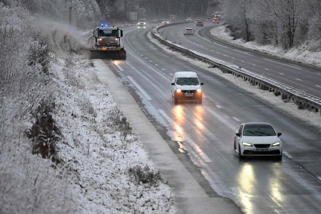 Vehicles move along a carriageway of the A30 motorway as they pass a snowplough at Fontoy, north-eastern France on January 2, 2026, after heavy snowfall struck the region. (Photo by Jean-Christophe VERHAEGEN / AFP)