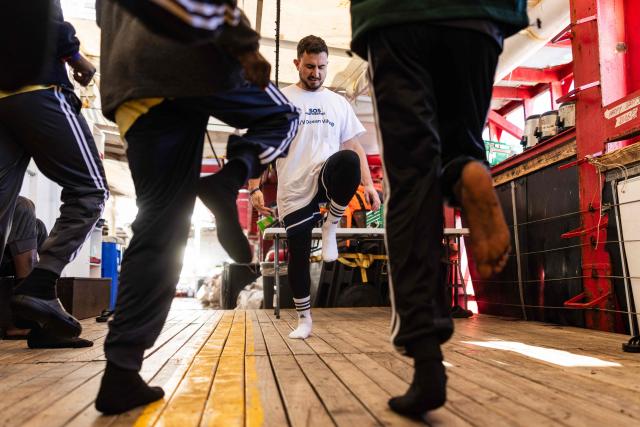 A member of the NGO SOS Mediterranee, exercises with migrants onboard the rescue ship "Ocean Viking" operated by humanitarian NGO SOS Mediterranee, in the Mediterranean Sea near the Italian coast on January 2, 2026. 33 migrants were rescued by crew members of the migrants rescue ship "Ocean Viking" operated by the NGO SOS Mediterranee. They had been stranded on the oil tanker the 'Maridive 703' since their initial rescue 5 days ago in the joint search zone between Malta and Tunisia in international Mediterranean waters. (Photo by Sameer Al-DOUMY / AFP)