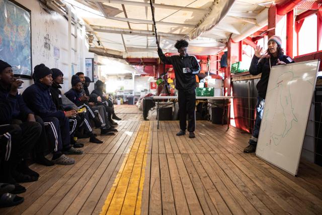 Migrants onboard of the rescue ship "Ocean Viking" operated by the NGO SOS Mediterranee, receive briefing regarding the designated port of disembarkation in Italy, as they sail in the Mediterranean Sea, near Italy, on January 2, 2026. 33 migrants were rescued by crew members of the migrants rescue ship "Ocean Viking" operated by the NGO SOS Mediterranee. They had been stranded on the oil tanker the 'Maridive 703' since their initial rescue 5 days ago in the joint search zone between Malta and Tunisia in international Mediterranean waters. (Photo by Sameer Al-DOUMY / AFP)
