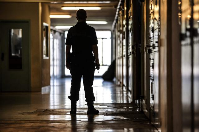 (FILES) A warder stands in a corridor at Gradignan prison, near Bordeaux, southwestern France, on October 3, 2022. There were 86,229 inmates in French prisons on December 1, 2025, marking another monthly increase amid chronic prison overcrowding, according to data published on January 2, 2026, by France's Ministry of Justice. (Photo by Thibaud MORITZ / AFP)