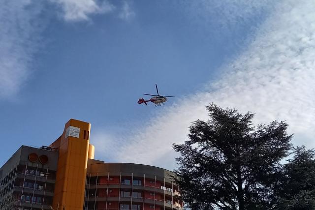 TOPSHOT - A helicopter leaves the hospital from which injured victims are being transferred, following the fatal bar fire in Sion near Crans-Montana on January 2, 2026. Some 40 people were killed and around 115 injured in the blaze at a bar in the luxury Swiss ski resort town of Crans-Montana on December 31, 2025, turning a New Year's celebration into one of the country's worst tragedies. From January 1, 2026, patients were transferred from Switzerland to hospitals in Germany, Italy and France after emergency units at local hospitals filled up. (Photo by Robin MILLARD / AFP)