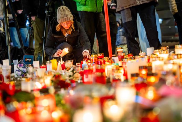 A mourner lights a candle at a makeshift memorial near the site of a fire that ripped through a bar during New Year's Eve celebrations in the Alpine ski resort town of Crans-Montana killing around 40 people and injuring more than 100 others, in Crans-Montana on January 2, 2026. Investigators raced on January 2, 2026 to identify the victims of a fire that ripped through a bar in the Swiss Alps town of Crans-Montana, turning a New Year's celebration into one of the country's worst tragedies. Frederic Gisler, police commander in the Wallis canton in southwestern Switzerland, told reporters that authorities had counted "around 40 people who have died and around 115 injured, most of them seriously". (Photo by MAXIME SCHMID / AFP)