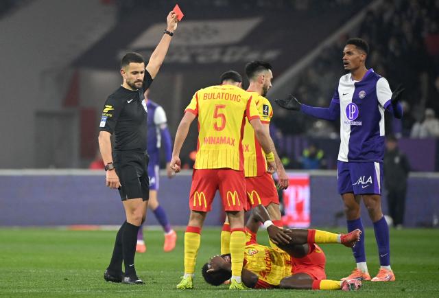 French referee Mathieu Vernice (L) shows Toulouse's Brazilian forward #20 Emersonn (R) a red card for a foul on Lens' French forward #11 Odsonne Edouard (2R) during the French L1 football match between Toulouse FC and RC Lens at the TFC Stadium in Toulouse, southwestern France, on January 2, 2026. (Photo by Matthieu RONDEL / AFP)