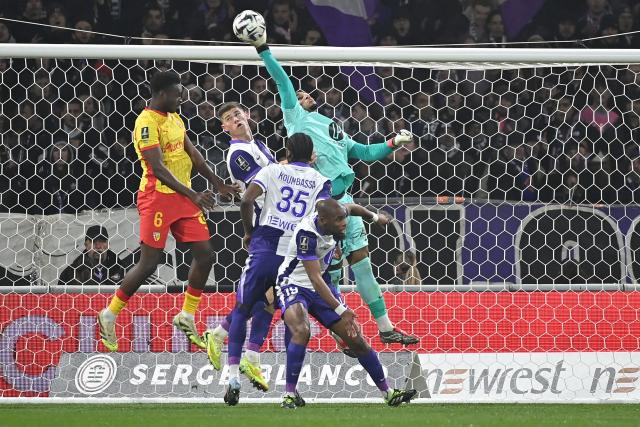 Toulouse's French goalkeeper #01 Guillaume Restes (R) stretches to save the ball during the French L1 football match between Toulouse FC and RC Lens at the TFC Stadium in Toulouse, southwestern France, on January 2, 2026. (Photo by Matthieu RONDEL / AFP)