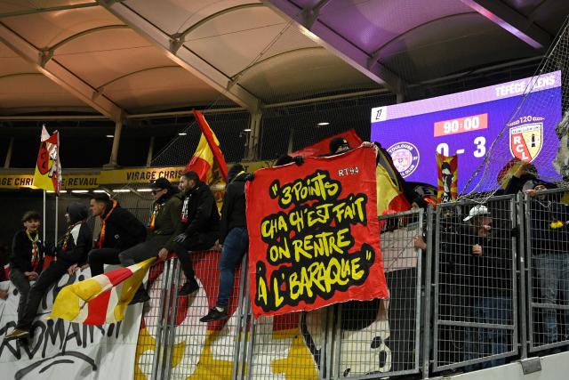 Lens' supporters hold a banner which reads "we take the three points and go home" in the stands at the end of the French L1 football match between Toulouse FC and RC Lens at the TFC Stadium in Toulouse, southwestern France, on January 2, 2026. (Photo by Matthieu RONDEL / AFP)