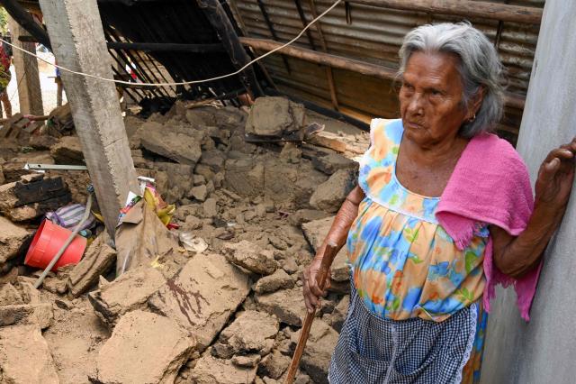 Nicolasa Salgado stands next to a damaged house after the earthquake, in the community of San Marcos, Guerrero state, Mexico, on January 2, 2026. A 6.5-magnitude earthquake rattled Mexico's capital and a tourist hotspot on  the Pacific coast on Friday, killing at least one person but causing no serious damage. (Photo by Francisco ROBLES / AFP)