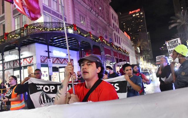 Protesters march through the French Quarter during a "No Trump, No Troops" rally against President Trump's immigration policies and Louisiana Governor Jeff Landry's National Guard deployment, in New Orleans, Louisiana on January 2, 2026. (Photo by Octavio JONES / AFP)