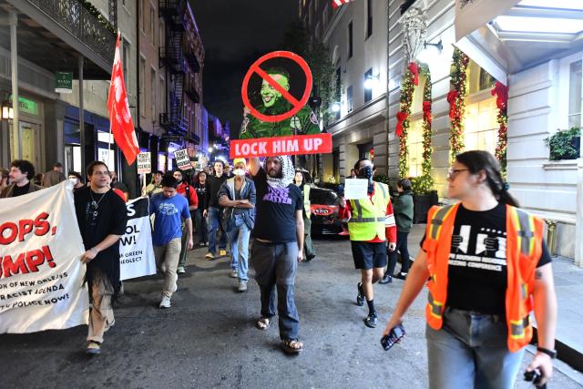 A protester holds an image of Gregory Bovino, chief patrol agent with the US Border Patrol, reading "Lock Him Up" during a "No Trump, No Troops" rally against Trump’s immigration policies and Louisiana Governor Jeff Landry’s National Guard deployment in New Orleans, January 2, 2026. (Photo by Octavio JONES / AFP)