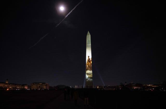 An image of George Washington is projected onto the Washington Monument during the "Illumination of America" event marking America’s 250th anniversary at the National Mall in Washington, DC, on January 2, 2026, as the January Wolf Supermoon rises in the back. (Photo by ANDREW CABALLERO-REYNOLDS / AFP)