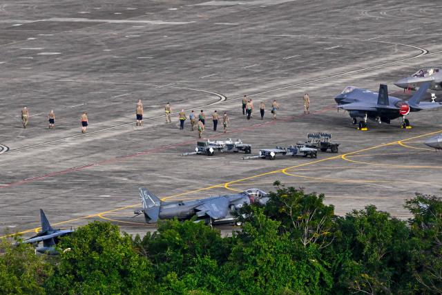Military personnel walk past fighter jets on the tarmac at José Aponte de la Torre Airport, formerly Roosevelt Roads Naval Station, in Ceiba, Puerto Rico, on January 2, 2026. The United States has deployed a major military force in the Caribbean and has recently intercepted oil tankers as part of a naval blockade against Venezuelan vessels it considers to be under sanctions. Since September, US forces have launched dozens of air strikes on boats that Washington alleges, without showing evidence, were transporting drugs. More than 100 people have been killed. (Photo by Miguel J. Rodriguez Carrillo / AFP)