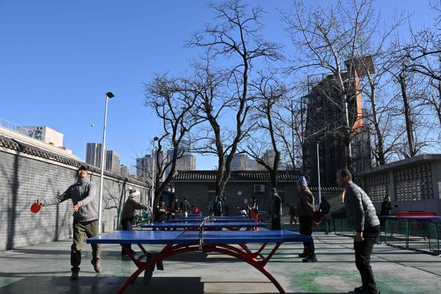 People play table tennis at a park in Beijing on January 3, 2026. (Photo by ADEK BERRY / AFP)