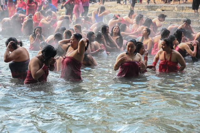 Hindu devotees take a holy dip in the Shali River on the occasion of the Swasthani Brata Katha festival on the outskirts of Kathmandu on January 3, 2026. (Photo by Prakash MATHEMA / AFP)