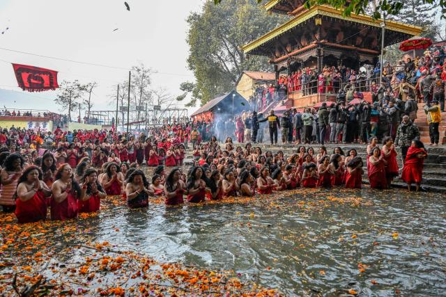 Hindu devotees take a holy dip in the Shali River on the occasion of the Swasthani Brata Katha festival on the outskirts of Kathmandu on January 3, 2026. (Photo by Prakash MATHEMA / AFP)