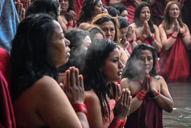 Hindu devotees pray while taking a holy dip in the Shali River on the occasion of the Swasthani Brata Katha festival on the outskirts of Kathmandu on January 3, 2026. (Photo by Prakash MATHEMA / AFP)