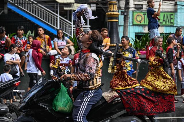 Catholic devotees are showered with holy water during the blessing of Jesus the Nazarene replicas at Quiapo in Manila on January 3, 2026, ahead of the annual "Black Nazarene" procession on January 9 that millions of Catholic devotees are expected to attend. (Photo by Jam STA ROSA / AFP)