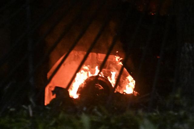 A vehicle burns at La Carlota air base in Caracas after a series of explosions on January 3, 2026. Loud explosions, accompanied by sounds resembling aircraft flyovers, were heard in Caracas around 2:00 am (0600 GMT) on January 3, an AFP journalist reported. The explosions come as US President Donald Trump, who has deployed a navy task force to the Caribbean, raised the possibility of ground strikes against Venezuela. (Photo by Juan BARRETO / AFP)