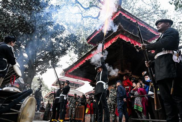 Nepali soldiers fire a gun-salute to pay respect to a girl revered as living goddess 'Kumari' on the occasion of the Changu Narayan Kalash Yatra festival in Kathmandu on January 3, 2026. (Photo by Prakash MATHEMA / AFP)